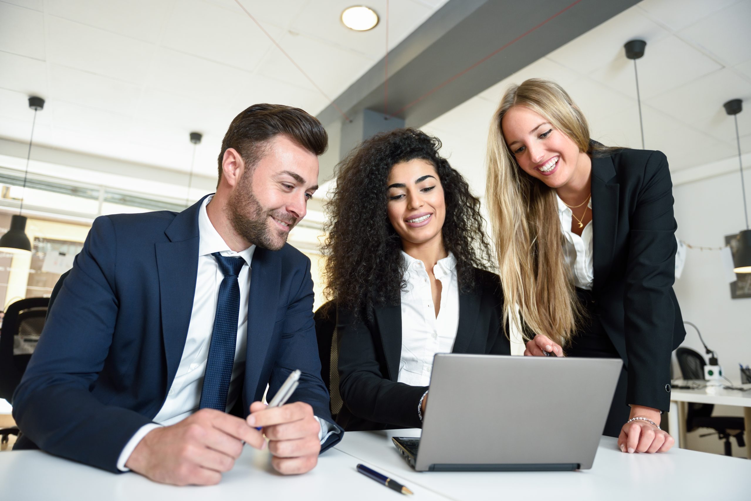 Multi-ethnic group of three businesspeople meeting in a modern o